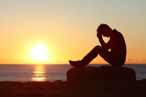 How to Recognize Addiction in Your Loved One - man sitting on beach - mountain laurel recovery center
