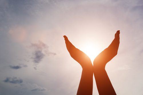 How Spirituality Helps Sobriety - hands held up around sun during sunset