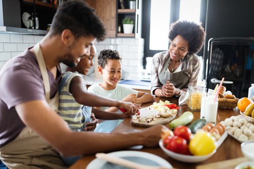 beautiful African American family cooking a healthy meal together - relationships