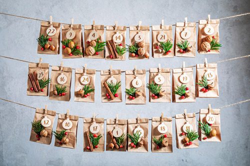 homemade advent calendar using small paper bags and various crafting items on string - newfound sobriety