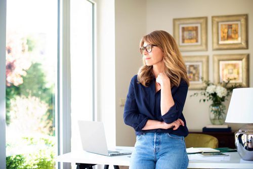 woman leaning against her desk at home thinking - cravings